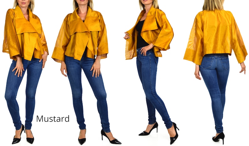 May include: A mustard yellow cropped jacket with a draped collar and wide sleeves. The jacket is worn over a black top and blue jeans.