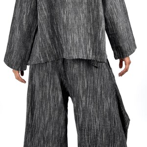 May include: A black and white striped long-sleeved top and pants set. The top has a collar and long sleeves. The pants are wide-legged and have a loose fit.