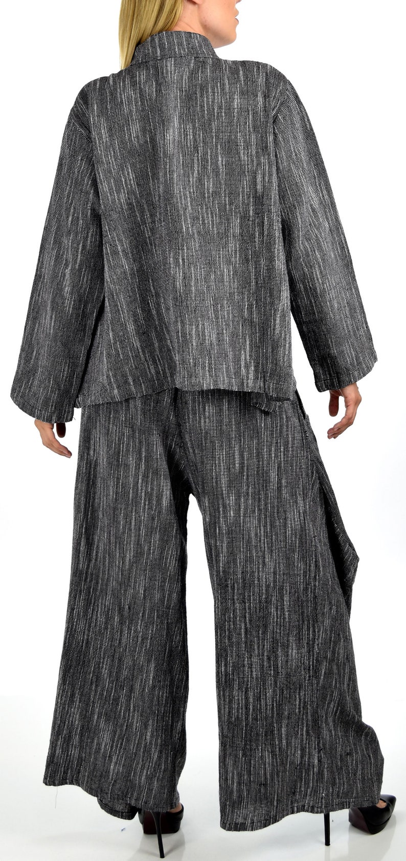 May include: A black and white striped long-sleeved top and pants set. The top has a collar and long sleeves. The pants are wide-legged and have a loose fit.