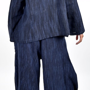 May include: A blue and black patterned long-sleeved top and wide-leg pants set. The top has a mandarin collar and the pants have a wide leg.