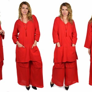 May include: A red tunic top with long sleeves and two pockets, paired with wide-legged pants. The outfit is made of a soft, flowing fabric.