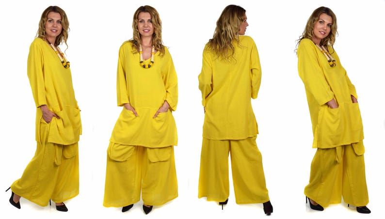 May include: A yellow two-piece outfit with a long-sleeved tunic top and wide-legged pants. The top has a V-neck and two large pockets. The pants have two large pockets on the front and a belt.