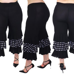 May include: Black cropped pants with a white polka dot ruffle trim. The pants have a wide leg and a comfortable fit.