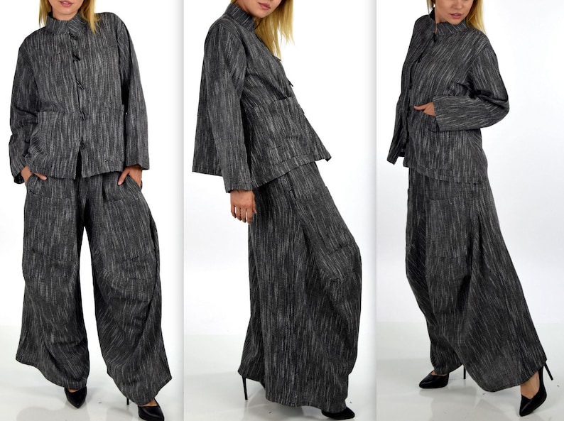 May include: A two-piece outfit in a gray and black striped fabric. The jacket has a mandarin collar and long sleeves. The pants are wide-legged and have a loose fit.