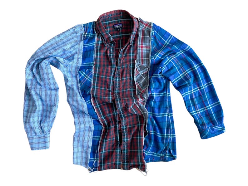 Peut inclure: Une chemise &agrave; carreaux &agrave; manches longues, r&eacute;alis&eacute;e en assemblant diff&eacute;rents morceaux de tissu. La chemise pr&eacute;sente un motif &agrave; carreaux bleus, rouges et blancs.