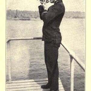 May include: A vintage black and white photograph of a navigator in a dark uniform and peaked cap standing on a wooden deck, holding a metal sextant to their eye to take a sight. The text "NAVIGATOR TAKING A SIGHT" and "[See p. 59]" appear below.