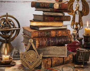 May include: A stack of antique leather-bound books sits on a map featuring pentagrams. Surrounding items include a brass armillary sphere, a gold-toned masonic square and compass emblem, a pyramid with an eye, a magnifying glass, and candles.