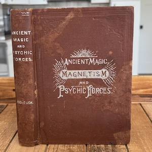May include: A vintage brown hardcover book titled Ancient Magic, Magnetism and Psychic Forces. The front cover features white embossed text and decorative line art. The spine also displays the title and the name Anderson in white lettering.