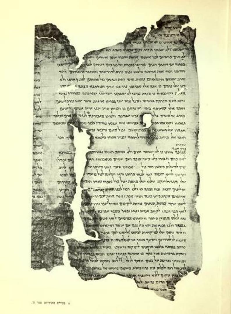 May include: An ancient, weathered parchment scroll fragment featuring dense, dark Hebrew text written in columns. The edges are frayed, torn, and uneven, with a small circular hole near the center and visible signs of aging and discoloration.
