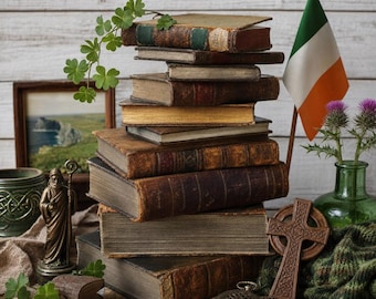 May include: A stack of antique leather-bound books sits beside an Irish flag, a small bronze statue of a figure with a staff, a wooden Celtic cross, a silver pocket watch, a green glass vase with thistle flowers, and a sprig of green clover.