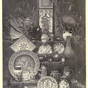 May include: A monochromatic collection of decorative objects including ceramic vases, ornate plates, a central bust of a child, a rectangular framed panel with a figure, and a sculpted face mask. The text at the bottom reads FROM THE AUTHOR'S COLLECTION.