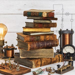 May include: A vertical stack of antique, weathered hardcover books with worn brown and tan leather spines, surrounded by vintage electrical components including a glowing light bulb, copper wire coils, a circular analog meter, and a telegraph key.