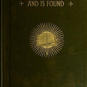 May include: A dark green hardcover book with gold embossed text reading THE BIBLE THAT WAS LOST AND IS FOUND. The cover features a central gold illustration of an open book surrounded by radiating sunburst lines and two small cross symbols.