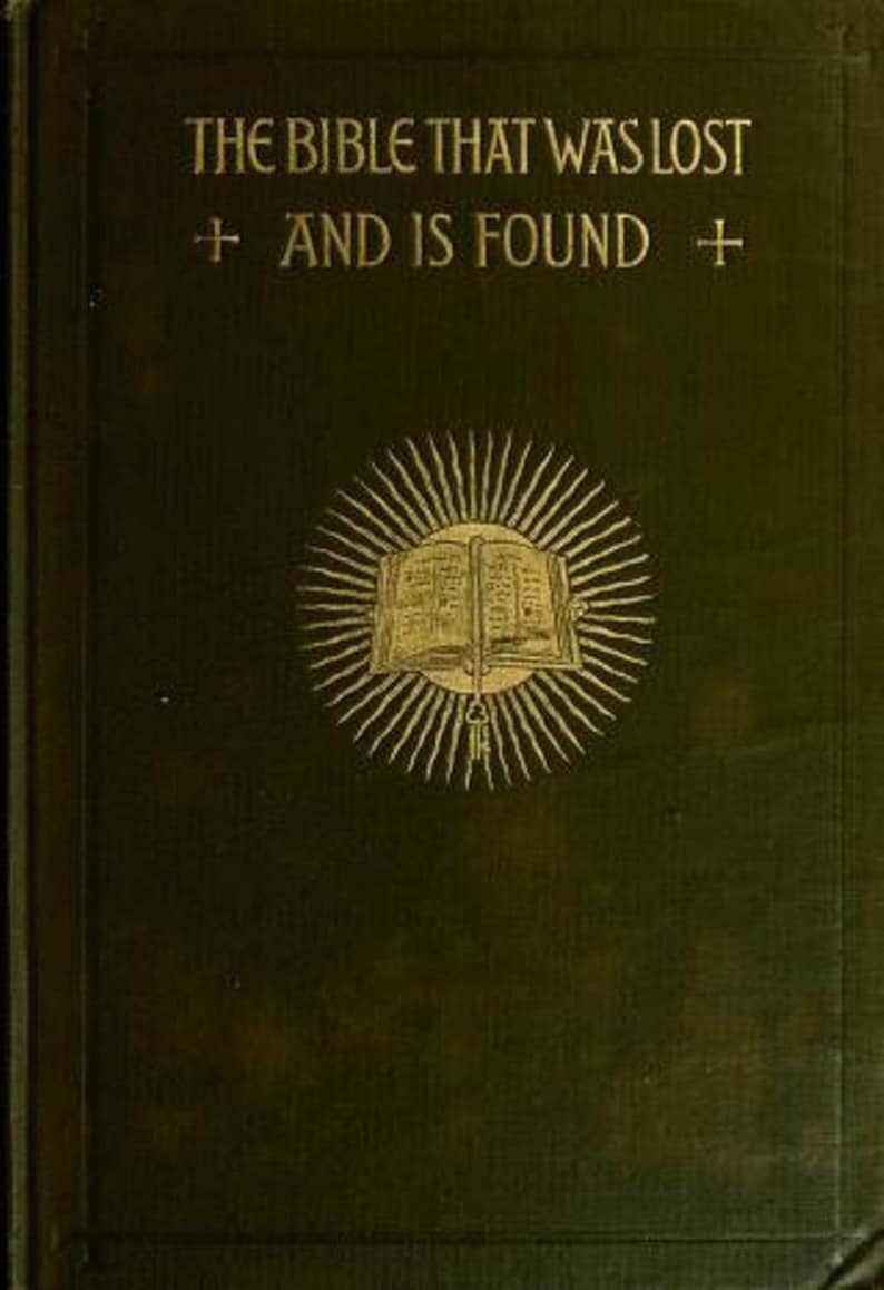 May include: A dark green hardcover book with gold embossed text reading THE BIBLE THAT WAS LOST AND IS FOUND. The cover features a central gold illustration of an open book surrounded by radiating sunburst lines and two small cross symbols.