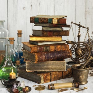 Könnte beinhalten: Ein Stapel antiker ledergebundener Bücher steht neben einer Messingwaage, einer Armillarsphäre, einem Mörser mit Stößel, Glasflaschen mit grünen und blauen Flüssigkeiten, einer brennenden Kerze in einem Metallhalter und verschiedenen Edelsteinen.