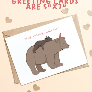 Pu&ograve; includere: Un biglietto di auguri con una busta marrone. Il biglietto presenta un'illustrazione a cartoni animati di una mamma orsa con un cucciolo di orso pi&ugrave; piccolo sulla schiena, entrambi con cappelli da festa. Il testo "happy birthday, mama bear!" &egrave; scritto sul biglietto. Il biglietto misura 12,7 cm x 17,8 cm.