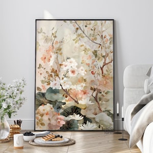 May include: A framed floral art print featuring a watercolor painting of white, peach, and pink flowers. The artwork includes green leaves and branches against a soft, neutral background. The black frame adds a modern touch.