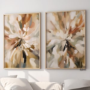 Könnte beinhalten: Zwei abstrakte Gemälde in Holzrahmen. Die Gemälde sind beide in Braun-, Beige- und Weißtönen gehalten, mit einem wirbelnden, abstrakten Design. Die Gemälde hängen an einer weißen Wand.