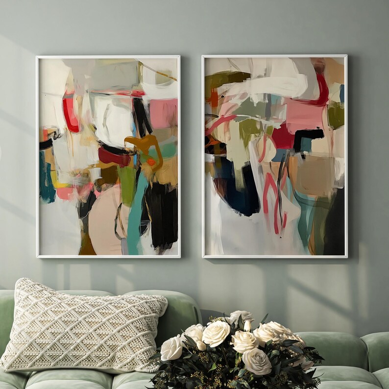 Puede incluir: Dos obras de arte abstractas enmarcadas. La obra presenta una mezcla de colores, incluyendo rojo, rosa, verde y negro, con marcos blancos. El estilo es moderno y expresivo, con pinceladas visibles y pintura en capas.