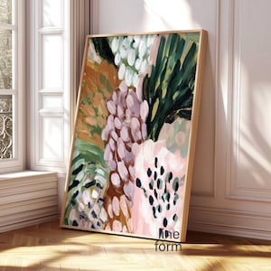 May include: Abstract art print with a wooden frame. The artwork features a colorful floral design with brushstrokes in shades of pink, green, white, and brown. The painting is leaning against a white wall and a window.