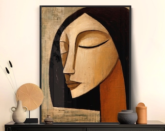 May include: Abstract painting of a woman's face with closed eyes, painted in shades of brown, black, and orange. The painting is framed in a black frame.
