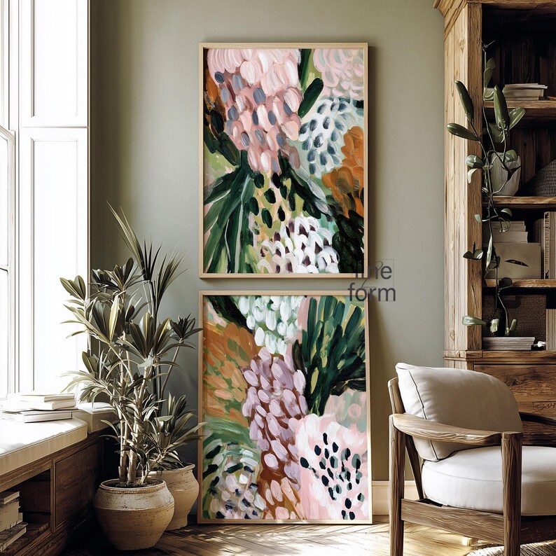 May include: Two framed abstract art prints. The artwork features a colorful floral design with pink, green, white, and orange brushstrokes. The frames are a light wood color, and the overall style is modern and decorative.