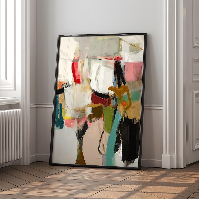 Puede incluir: Impresi&oacute;n art&iacute;stica abstracta en un marco negro. La obra presenta una mezcla de colores, incluyendo rojo, rosa, negro y turquesa, con pinceladas y formas. La pintura se apoya en una pared blanca y un suelo de madera.