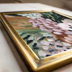 May include: Abstract art painting in a gold frame. The artwork features a blend of colors, including pink, green, brown, and white, with visible brushstrokes. The frame has a metallic gold finish. The text "line form" is visible in the lower right corner.
