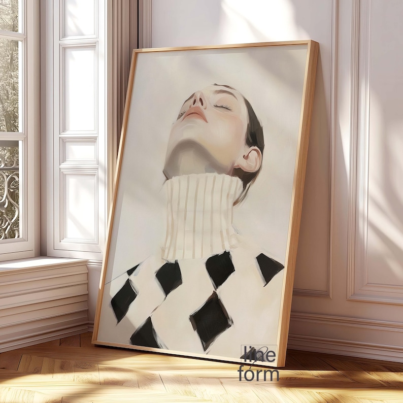 Puede incluir: Impresi&oacute;n art&iacute;stica enmarcada que presenta un retrato de una persona con los ojos cerrados, con un jersey de cuello alto blanco y una parte superior con estampado de rombos en blanco y negro. La obra est&aacute; en un marco de madera clara.