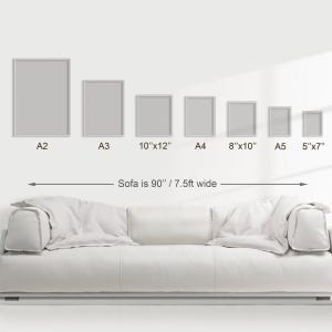 Puede incluir: Un sof&aacute; blanco con una serie de impresiones art&iacute;sticas enmarcadas en varios tama&ntilde;os, incluyendo A2, A3, 10"x12", A4, 8"x10", A5 y 5"x7". El sof&aacute; mide 229 cm de ancho. Las impresiones se muestran en una pared blanca.