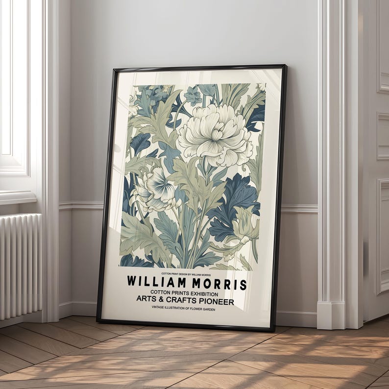 Peut inclure: Une affiche encadr&eacute;e avec un motif floral dans des tons de blanc, bleu et vert. L'impression comprend le texte "WILLIAM MORRIS COTTON PRINTS EXHIBITION ARTS & CRAFTS PIONEER". L'&oelig;uvre est pr&eacute;sent&eacute;e dans un cadre noir.