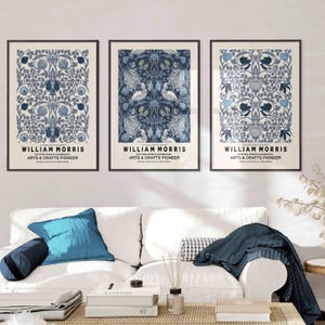 Pu&ograve; includere: Tre stampe artistiche incorniciate con disegni di William Morris. Ogni stampa presenta intricati motivi floreali e di uccelli in tonalit&agrave; blu e bianco. Il testo "WILLIAM MORRIS COTTON PRINTS EXHIBITION ARTS & CRAFTS PIONEER" &egrave; visualizzato in basso in ogni cornice.