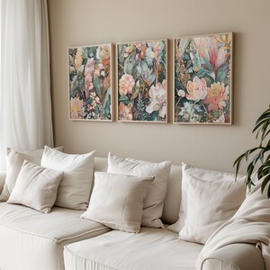 Puede incluir: Tres impresiones florales enmarcadas con una mezcla de tonos rosas, verdes y marrones. Las impresiones presentan una variedad de flores y hojas, creando una escena bot&aacute;nica exuberante y vibrante.