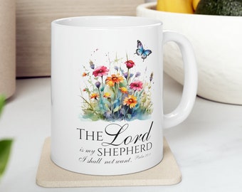 May include: White ceramic mug with a floral design and a blue butterfly. The mug has a black inscription that reads "The Lord is my Shepherd I shall not want. Psalm 23:1"