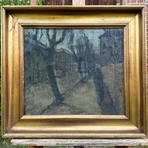 May include: An oil painting in a gold frame shows a landscape with trees and buildings. The artwork uses a muted palette of blues, greens, and browns, creating a moody atmosphere. The ornate gold frame enhances the vintage aesthetic of the painting.