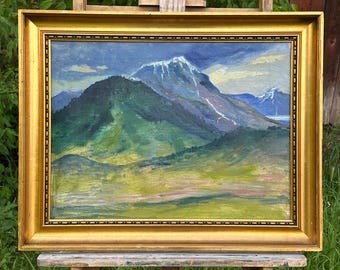 May include: Oil painting of a mountain landscape in a gold frame. The artwork depicts a mountain range with snow-capped peaks under a cloudy sky. The foreground features green and yellow fields.
