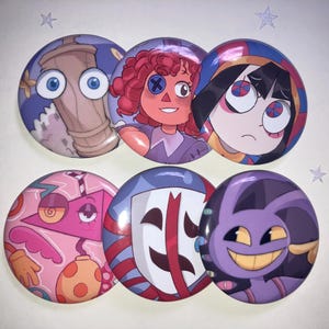 Könnte beinhalten: Ein Set aus sechs runden Ansteckbuttons mit farbenfrohen Cartoon-Charakter-Illustrationen. Die Motive zeigen einen Holzzylinder mit blauen Augen, eine rothaarige Puppe, eine Figur mit dunklem Haar, eine rosa geometrische Form, eine weiße Maske und ein lila Wesen.
