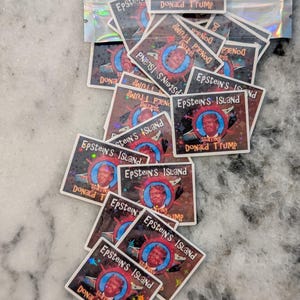 Puede incluir: Un conjunto de pegatinas cuadradas con el texto "Epstein's Island Starring Donald Trump". Las pegatinas presentan un retrato en un c&iacute;rculo azul, sobre un fondo rojo, marr&oacute;n y negro.
