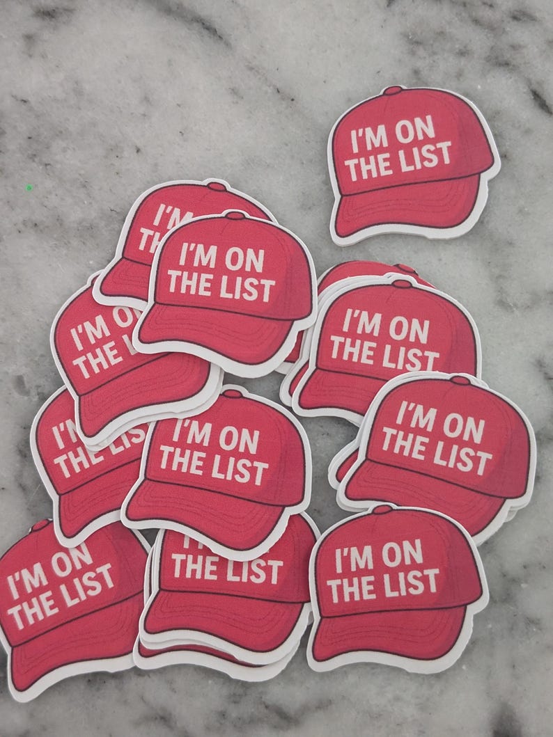 May include: A collection of red baseball cap stickers with the text "I'M ON THE LIST" in white. The stickers are scattered on a light gray surface. The caps have a classic design.