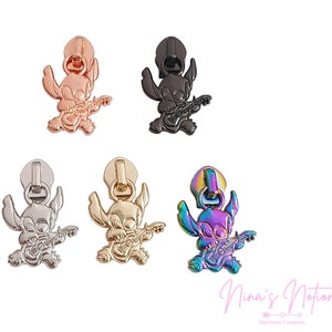 May include: Five zipper pulls featuring a cartoon character playing a guitar. The pulls are in different colors: rose gold, black, silver, gold, and iridescent.