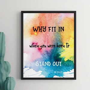 May include: A watercolor print with a rainbow background and the quote "WHY FIT IN when you were born to STAND OUT" by Dr. Seuss.