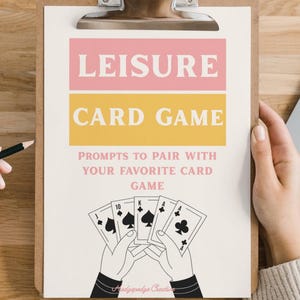 Puede incluir: Un portapapeles con un diseño de juego de cartas rosa y amarillo. El texto dice "LEISURE CARD GAME" y "PROMPTS TO PAIR WITH YOUR FAVORITE CARD GAME". Debajo del texto hay ilustraciones de naipes sostenidos por manos.