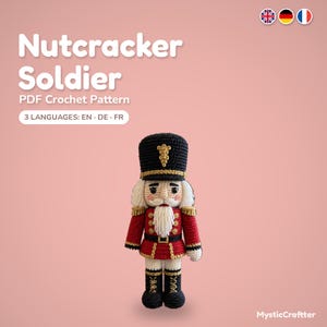 May include: A crochet nutcracker soldier doll with a black hat, red jacket, and white beard. The text reads: Nutcracker Soldier PDF Crochet Pattern, 3 LANGUAGES: EN DE FR, and MysticCraftter. The doll features gold accents and embroidery.
