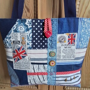 May include: A blue and white patchwork tote bag with a red and white polka dot ribbon, a red button, and a blue and white checked fabric. The bag has a Union Jack flag and text that reads "In Popular Music The Rise of Punk in the Late 1970s, Incorporated from the Culture of New York, the Sex Pistols around London, a National Movement that they Cause the Crash. The Rise of Punk in the Late 1970s."