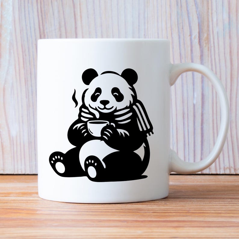 May include: White ceramic mug featuring a black and white illustration of a panda bear. The panda is wearing a scarf and holding a cup, with steam rising from it. The mug has a curved handle and is set against a wooden background.