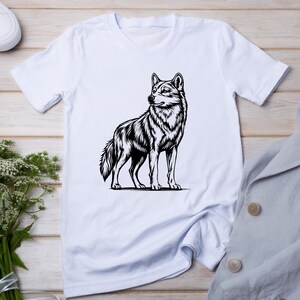 May include: White t-shirt with a black and white illustration of a wolf on the front.