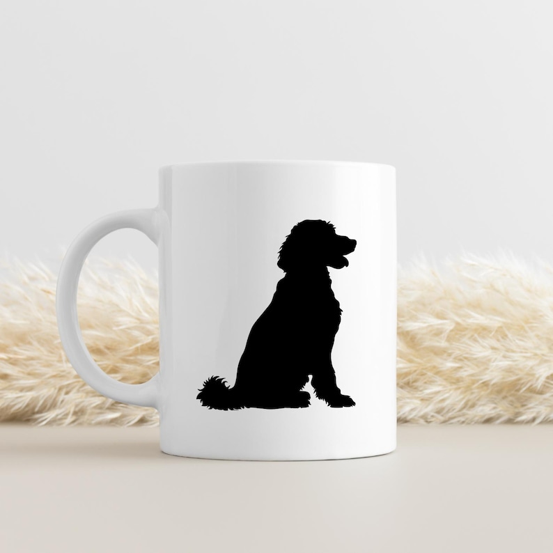 May include: White ceramic mug with a black silhouette of a poodle sitting. The poodle is facing to the right.