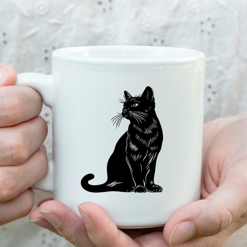May include: White ceramic mug featuring a black silhouette of a cat sitting and looking to the right.