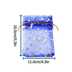 Peut inclure: Un sac cadeau en organza bleu avec des &eacute;toiles dor&eacute;es et des croissants de lune imprim&eacute;s dessus. Le sac mesure 16 cm de haut et 11 cm de large.