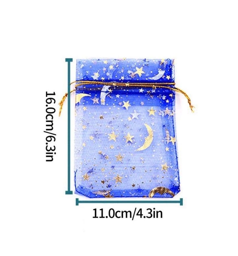 Peut inclure: Un sac cadeau en organza bleu avec des &eacute;toiles dor&eacute;es et des croissants de lune imprim&eacute;s dessus. Le sac mesure 16 cm de haut et 11 cm de large.